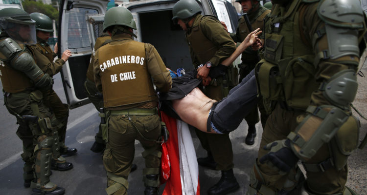 The police arrest a demonstrator during clashes between protesters and the police at Plaza de Maipu in Santiago, on October 19, 2019. - Chile's president declared a state of emergency in Santiago Friday night and gave the military responsibility for security after a day of violent protests over an increase in the price of metro tickets. (Photo by Pablo VERA / AFP)